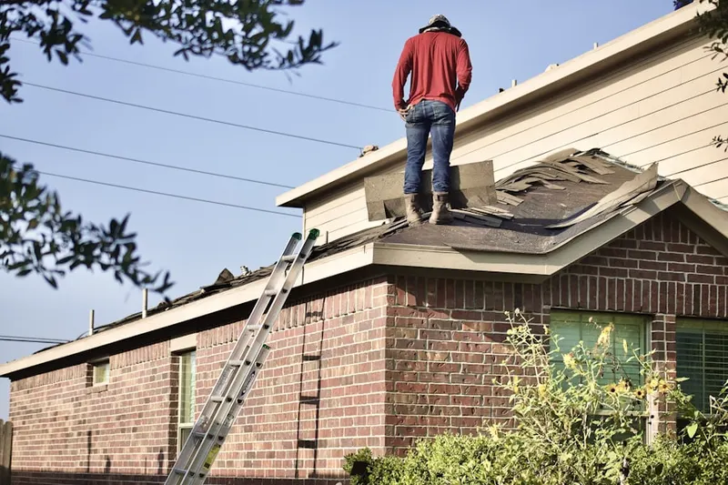 Professional roofer working on a residential roof in Morris Park Farms